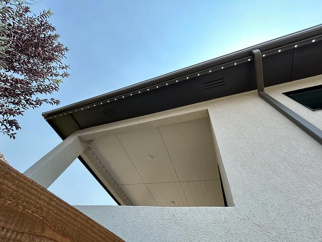 Close-up of the soffit showing the low-profile permanent lighting track in daylight