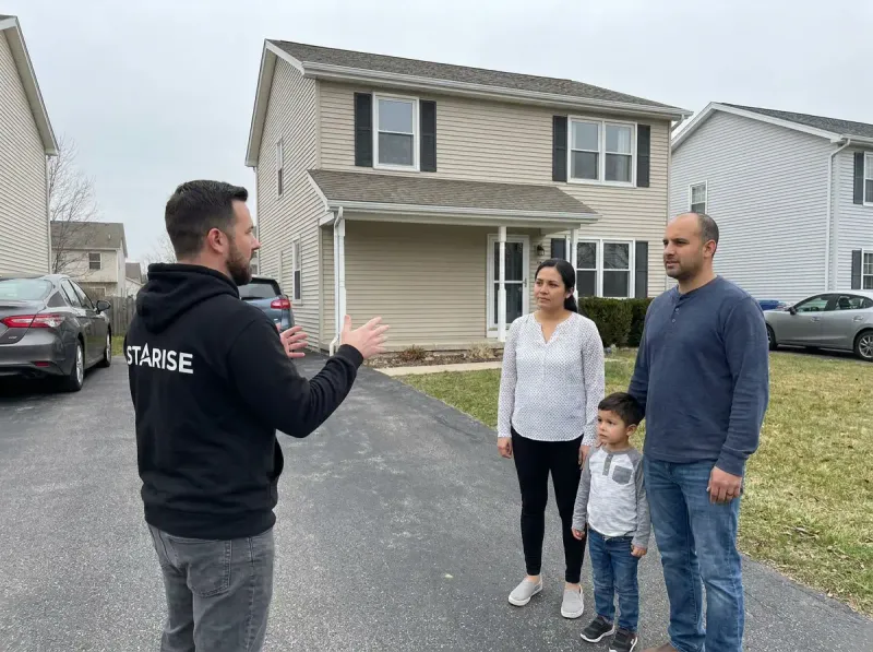 Starise estimator reviewing a lighting quote with homeowners at golden hour