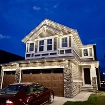 Home with Starise permanent lighting glowing on a winter night