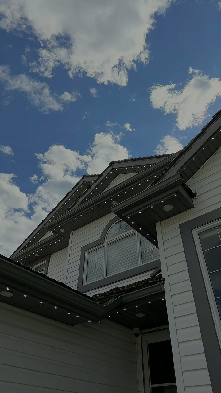 Individual permanent LED puck lights recessed under the eaves and peaks of a Calgary home