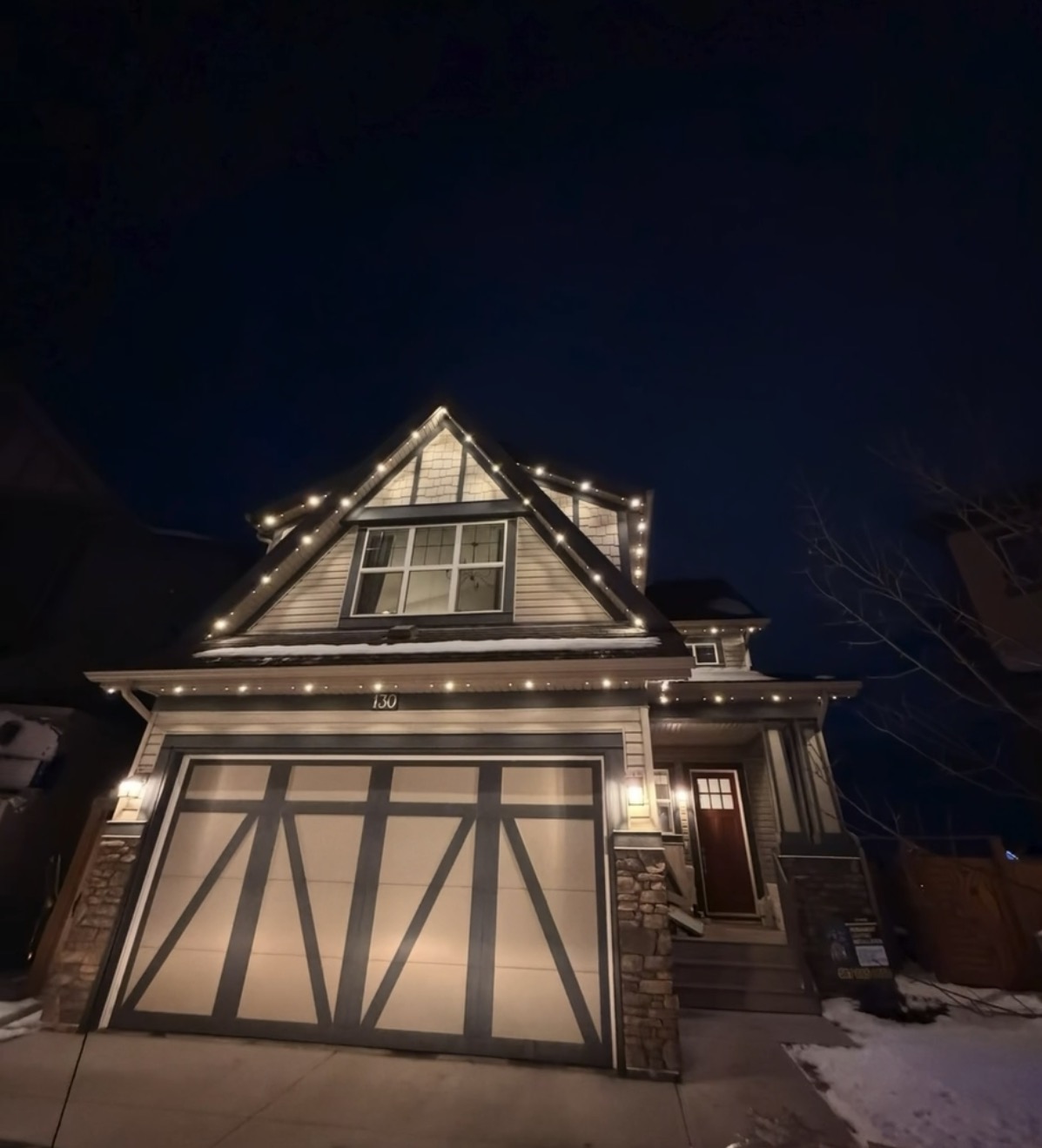 Warm amber permanent roofline lighting on Calgary home during autumn