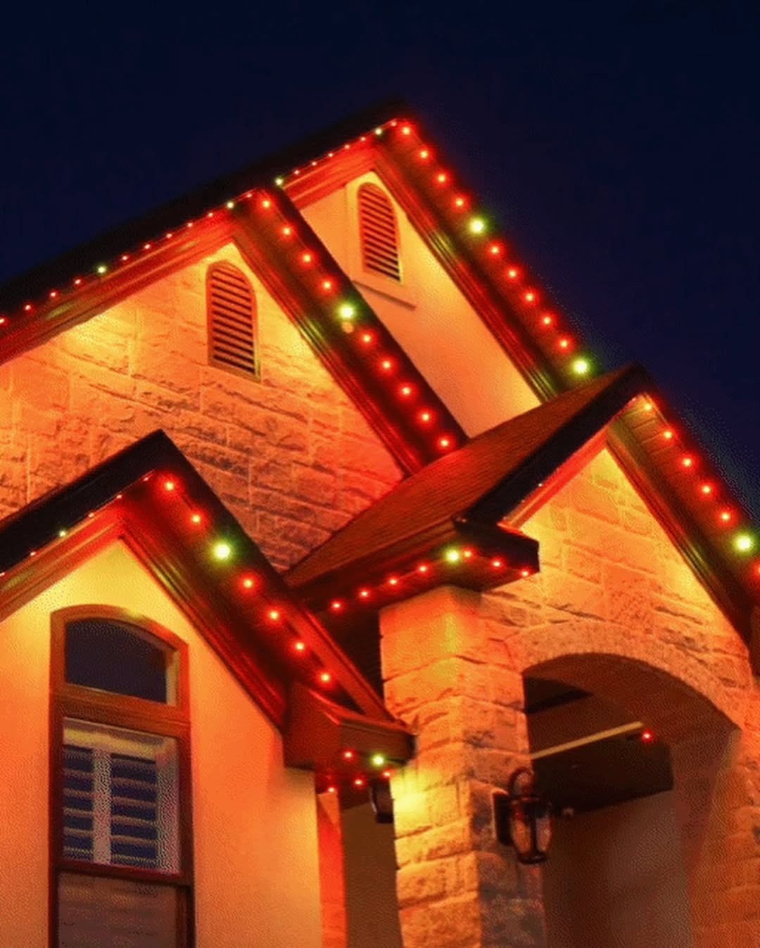 Festive red and green permanent Christmas lighting display on Calgary roofline
