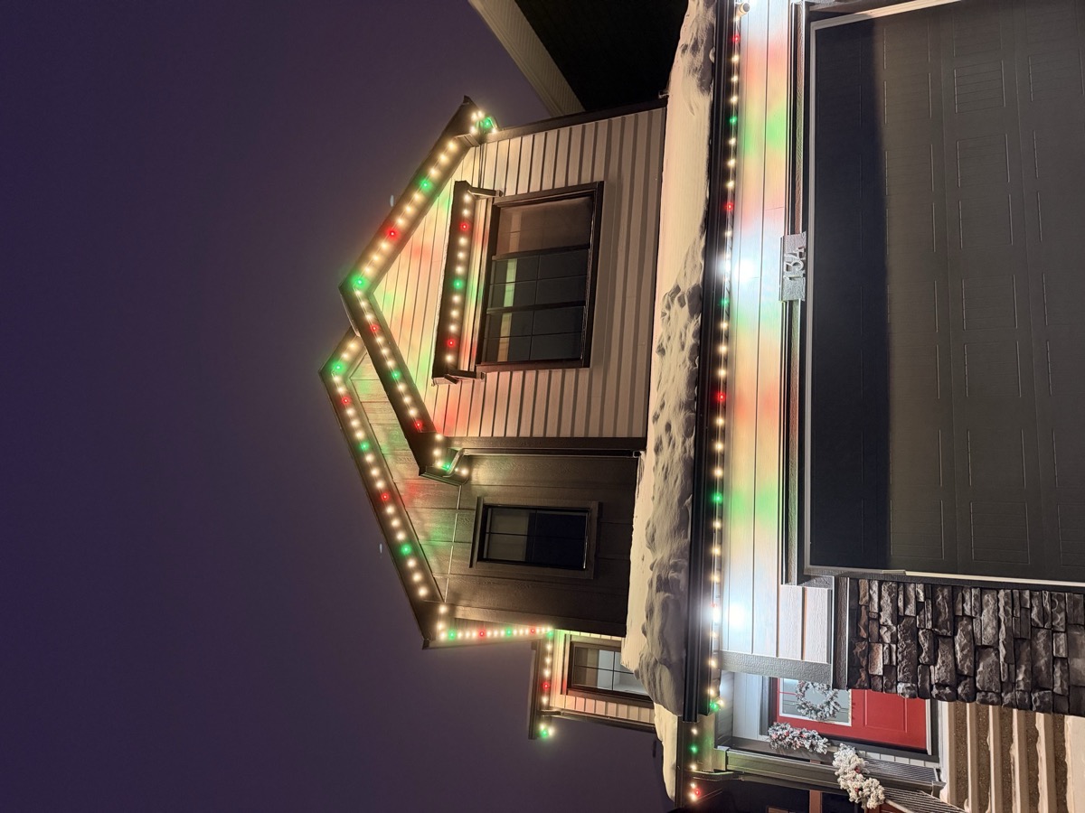 Permanent LED holiday lights along roofline and porch on Calgary home