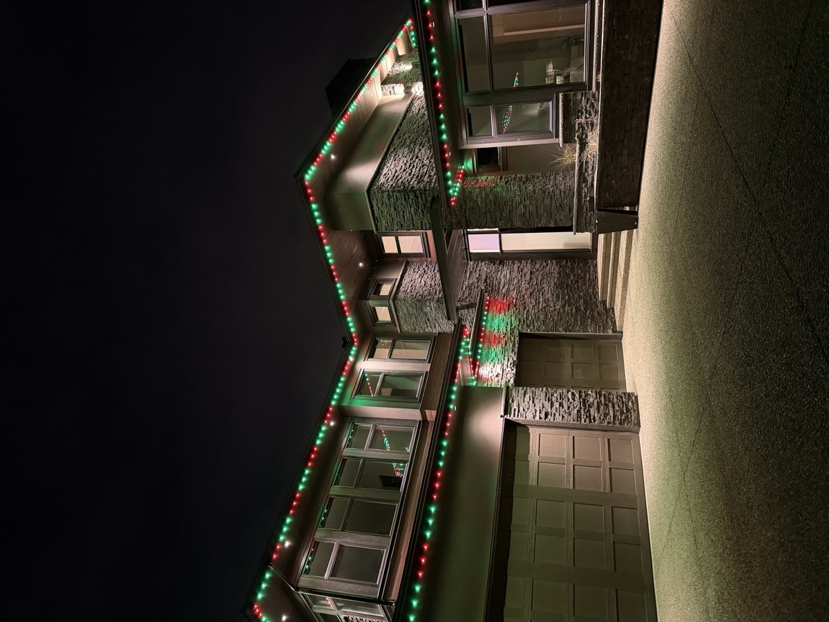 Multi-color permanent LED Christmas lights on Calgary two-storey suburban home