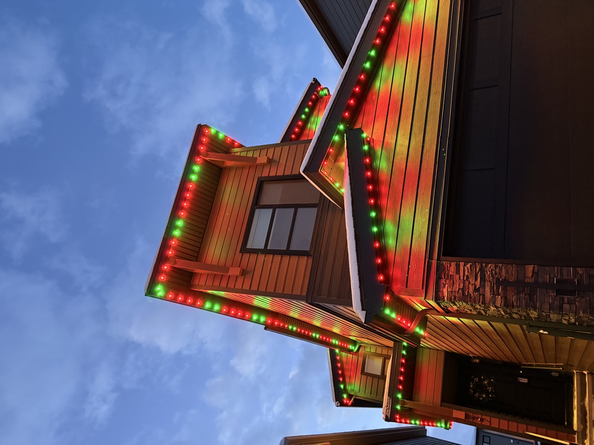 Red and white candy cane permanent LED holiday pattern on Calgary home roofline